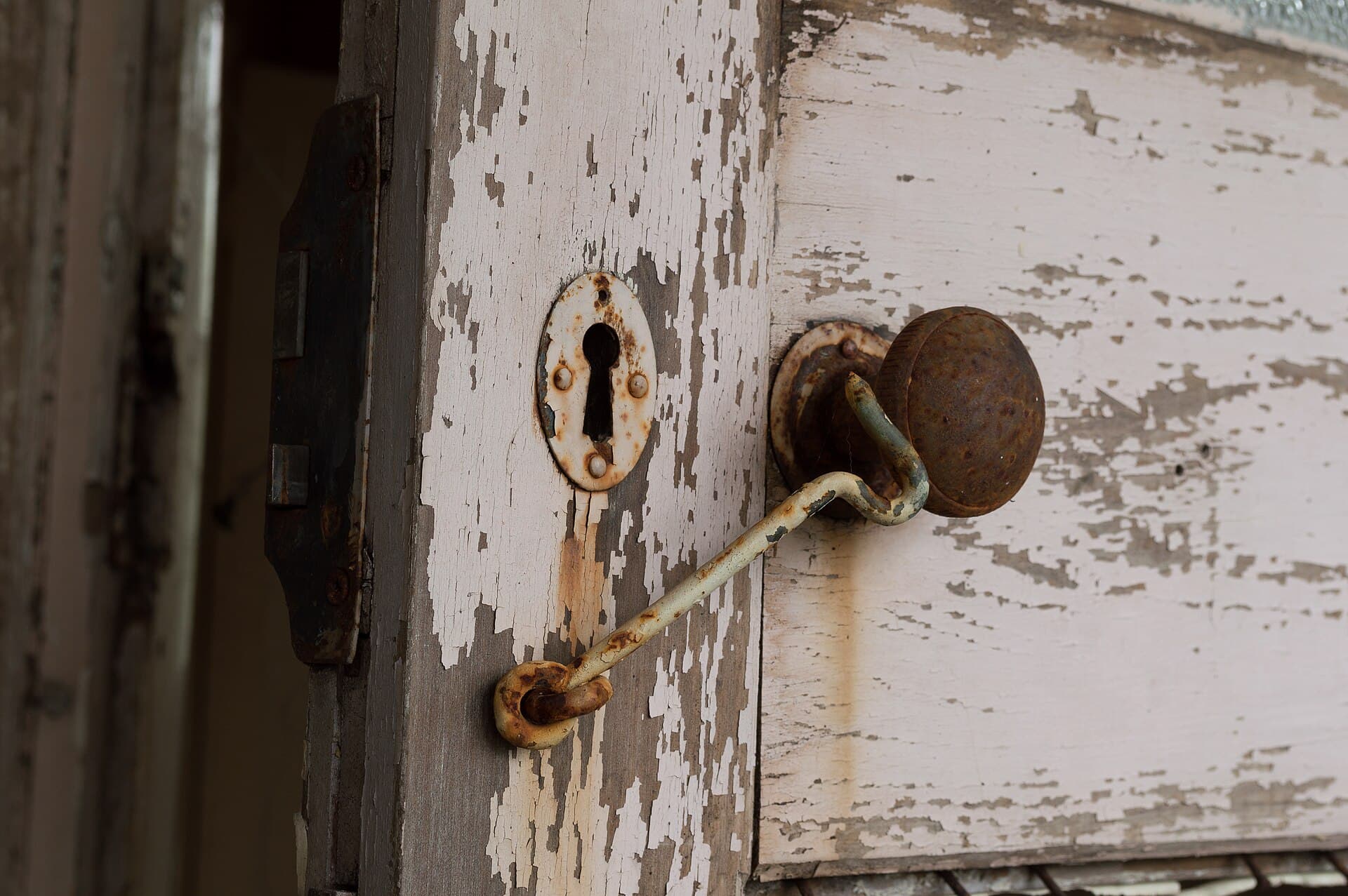 Rusted and pitted door knob on a weathered exterior door